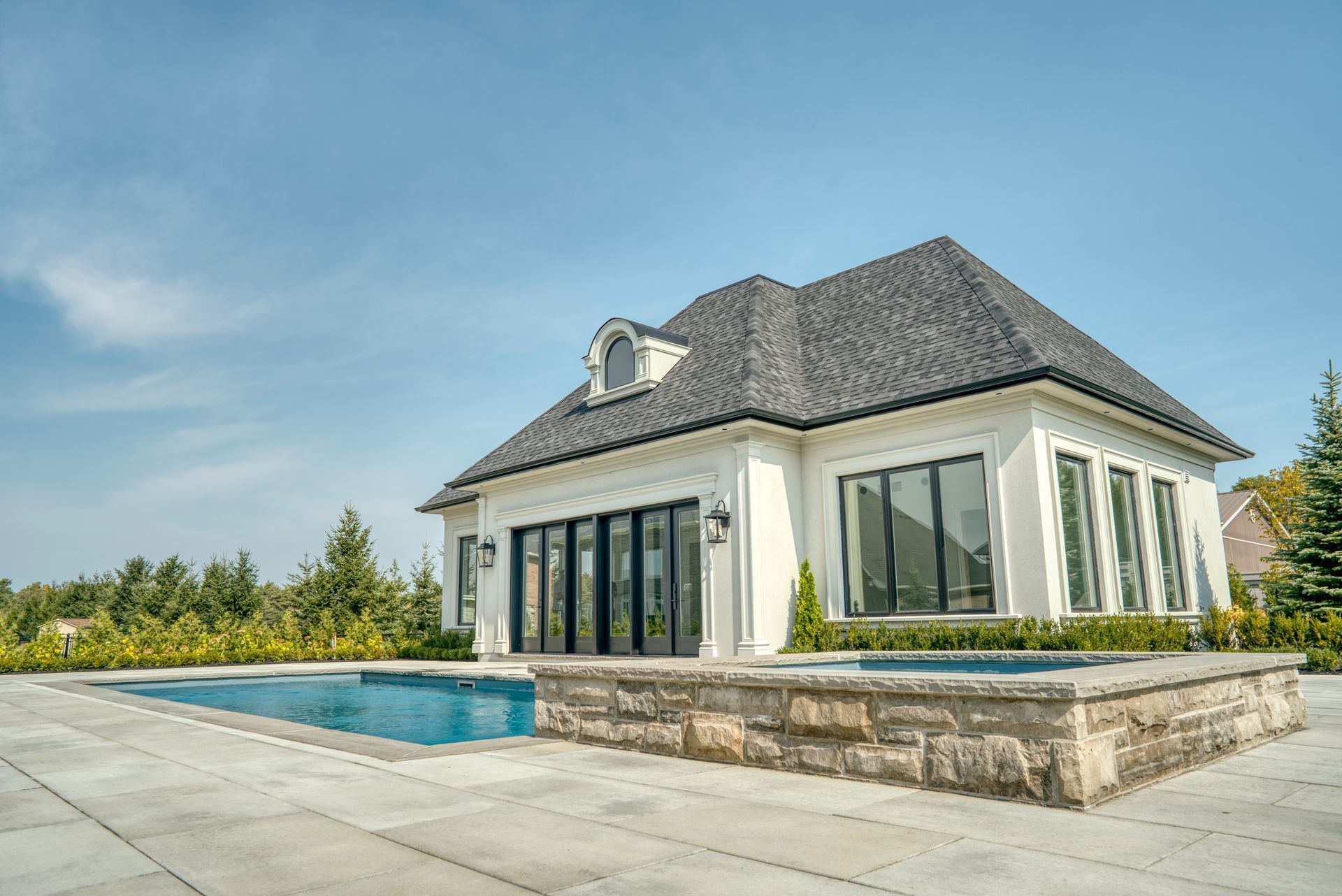 A large white house with a large swimming pool in front of it.