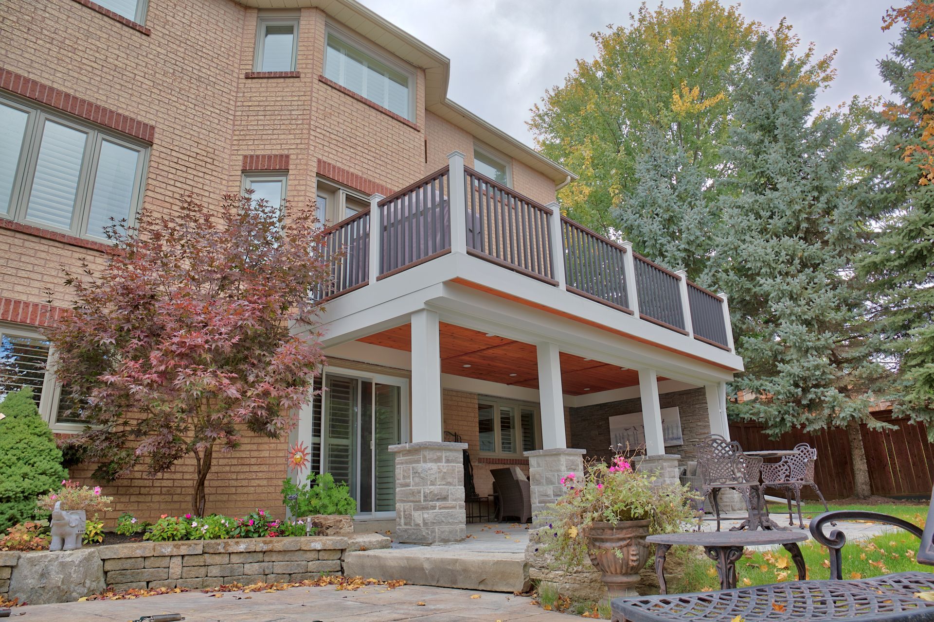 A large brick house with a large deck in front of it.