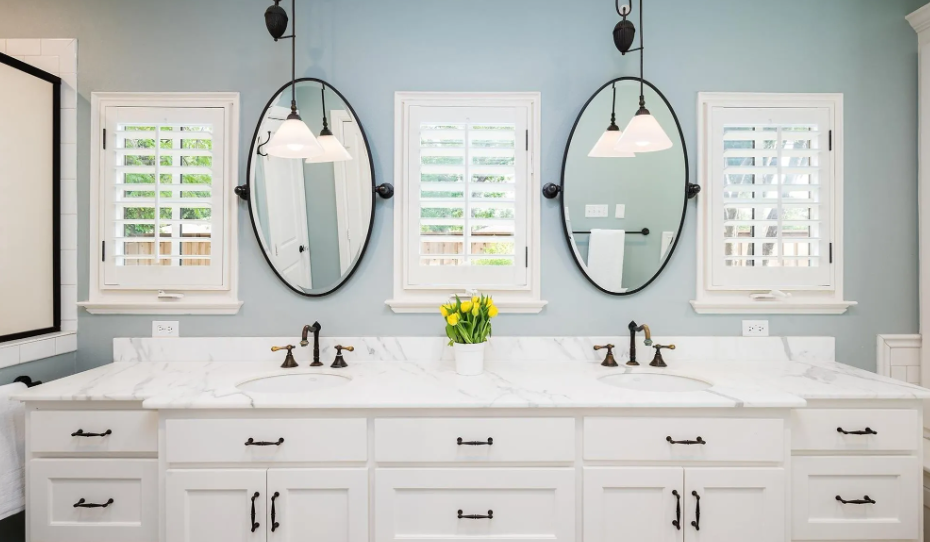 A bathroom with two sinks and three mirrors on the wall.