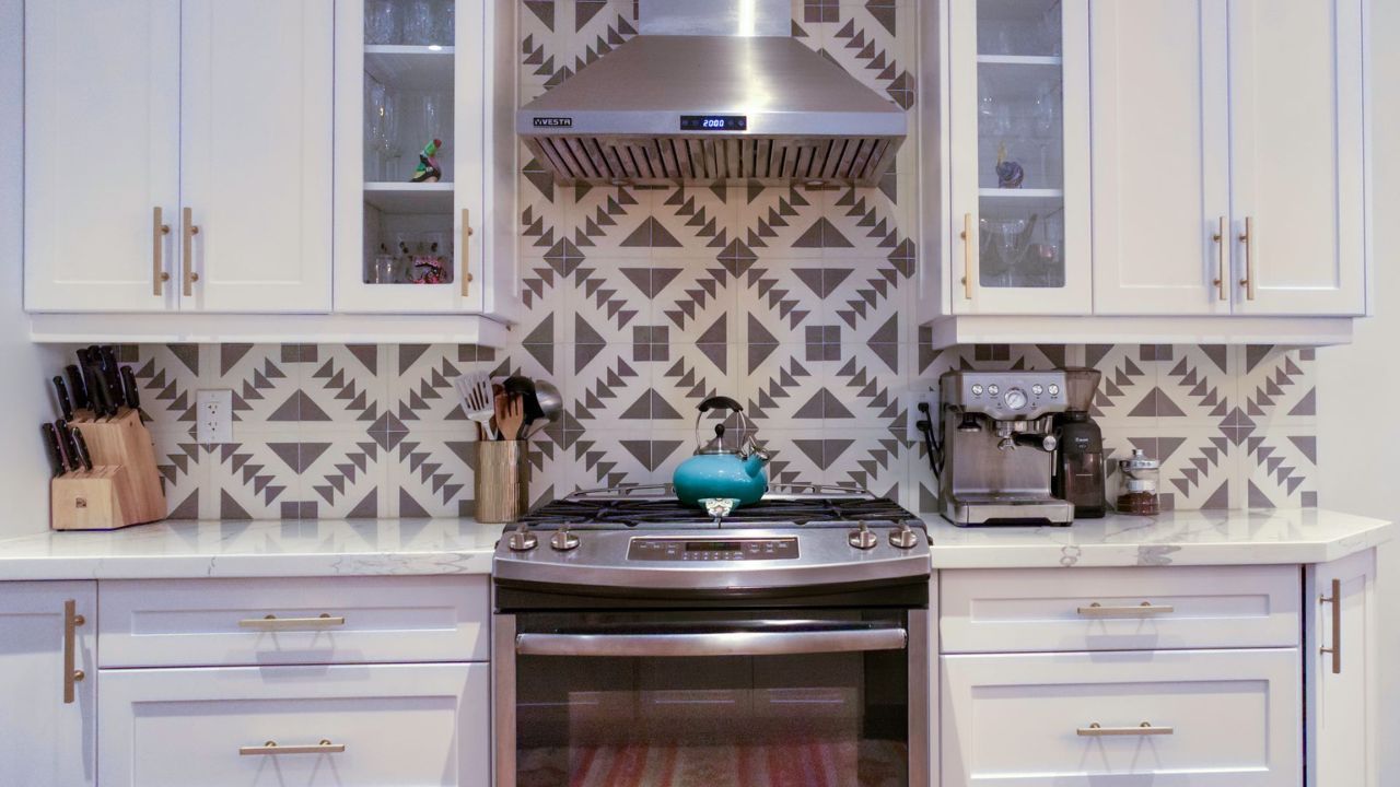 MSD Contracting Completed Kitchen Renovation with white cabinets, stainless steel appliances, and patterned backsplash.
