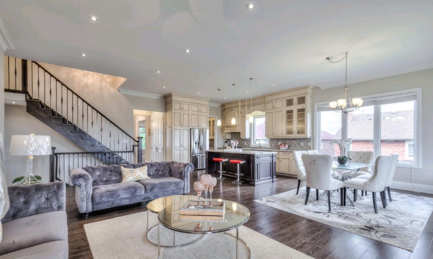 A living room filled with furniture and a staircase leading to the second floor.