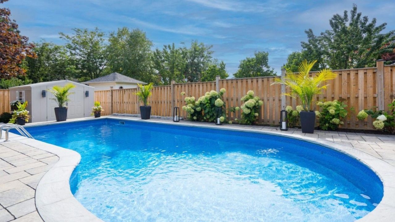 A large swimming pool surrounded by plants and a wooden fence. MSD Contracting Project