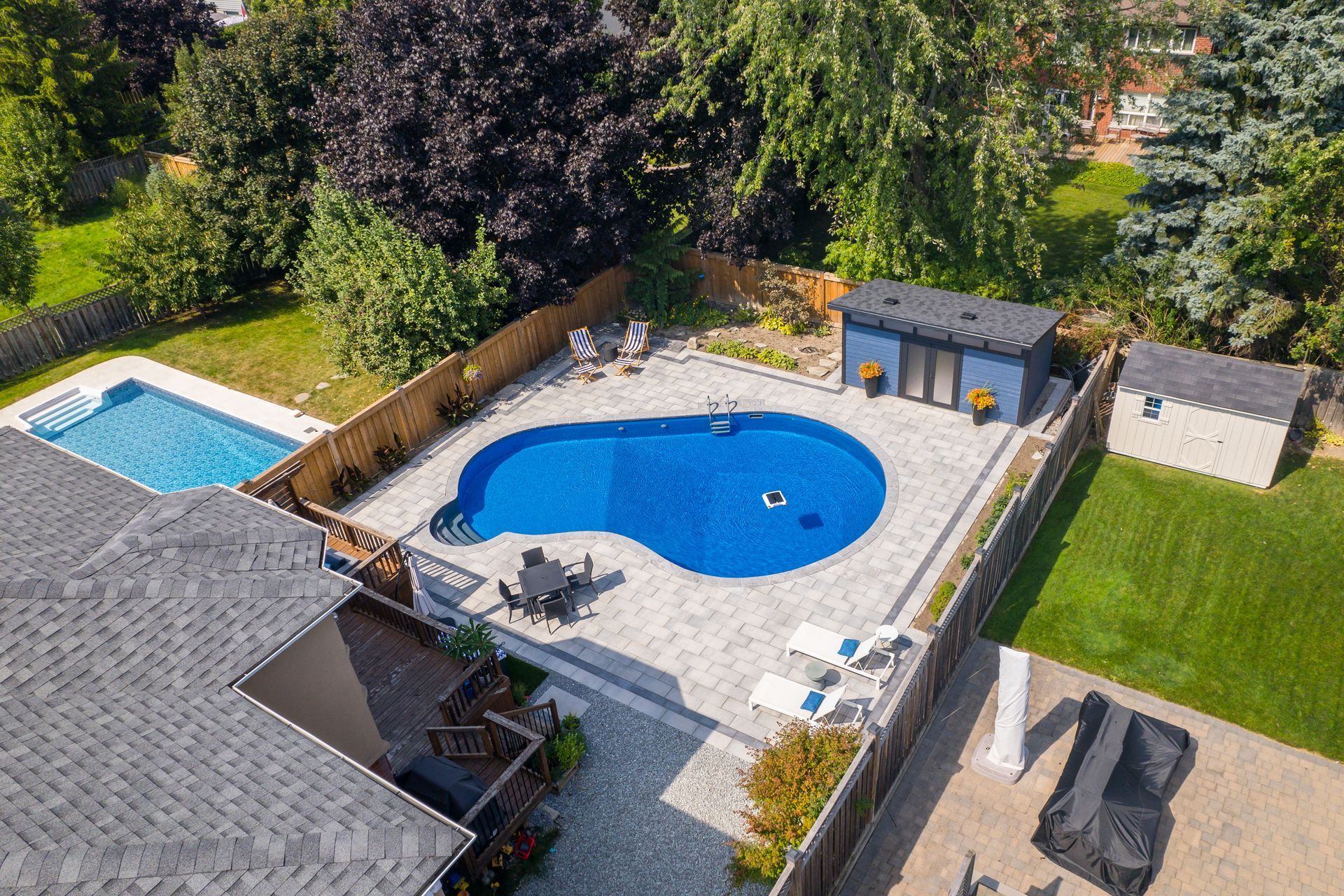An aerial view of a large swimming pool in the backyard of a house.