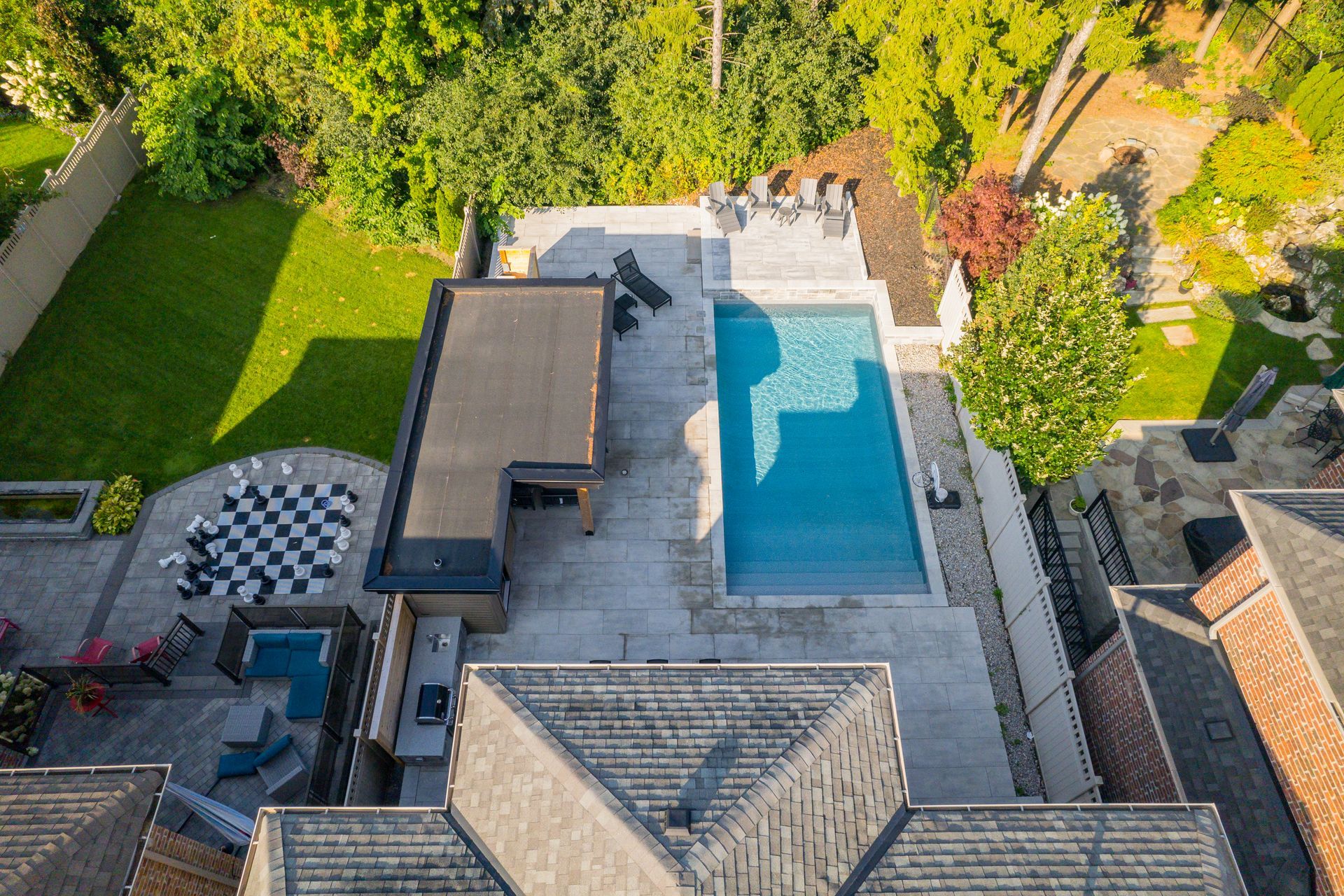 An aerial view of a house with a large swimming pool in the backyard.