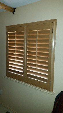 A window with wooden shutters on it in a room.