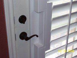 A close up of a door with shutters and a door handle.