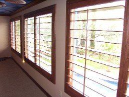 A hallway with a lot of windows and a ceiling fan.