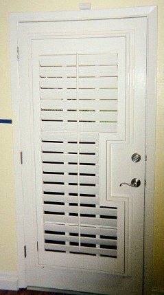 A white door with shutters on it is in a room.