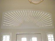 There is a fan on the ceiling above the door.