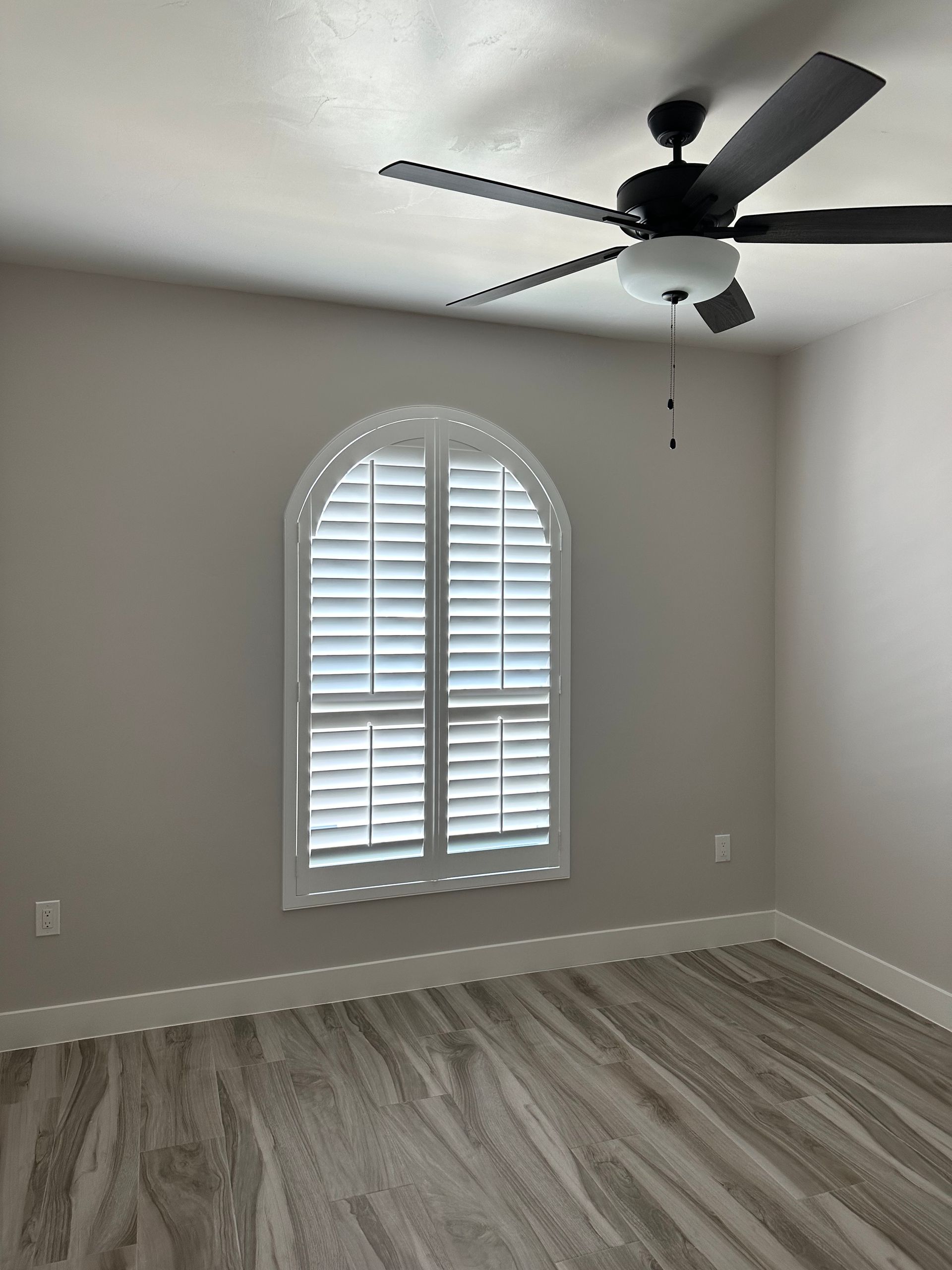 There is a ceiling fan in the corner of the room.