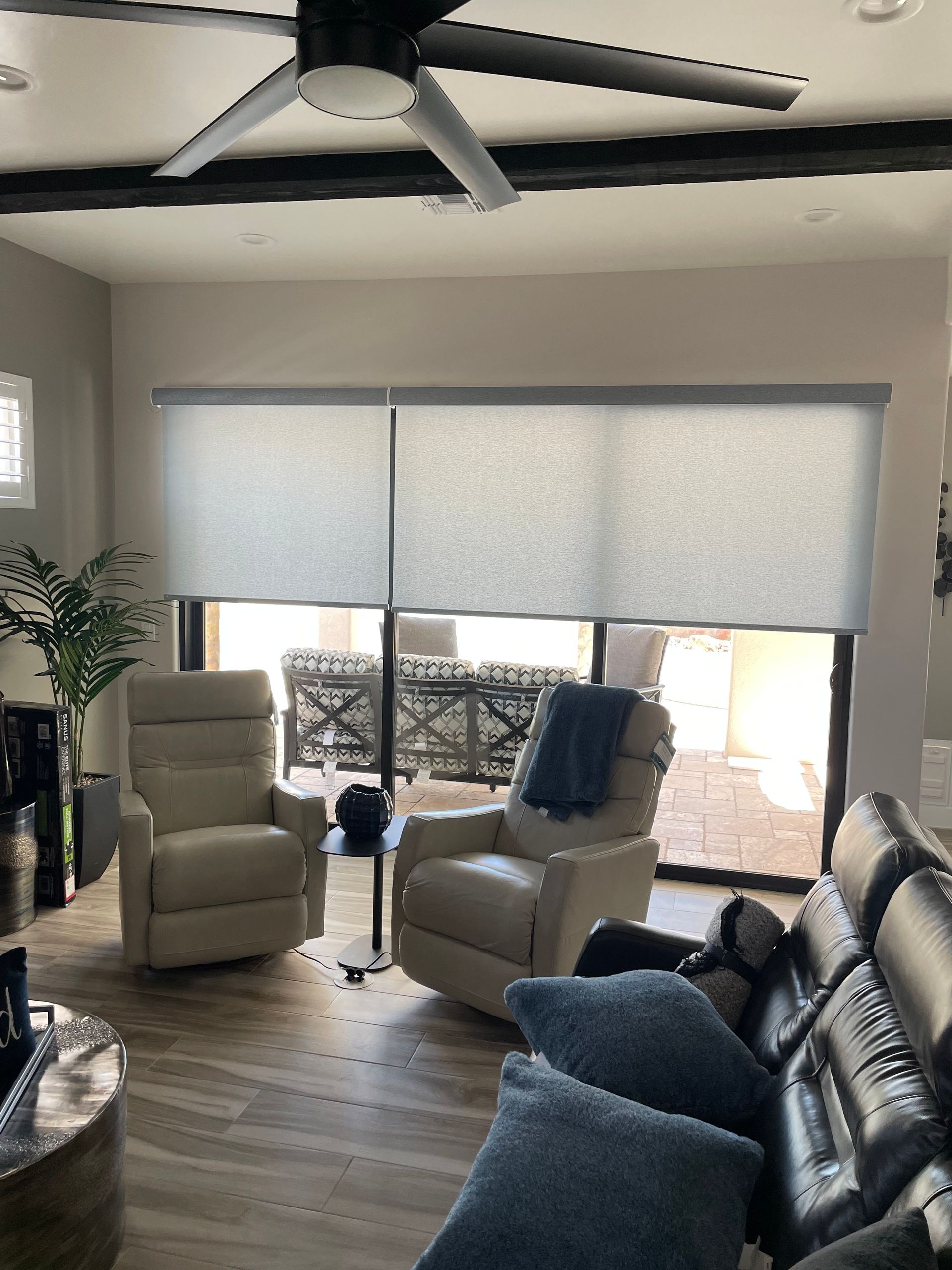 A living room with a couch , chairs , and a ceiling fan.