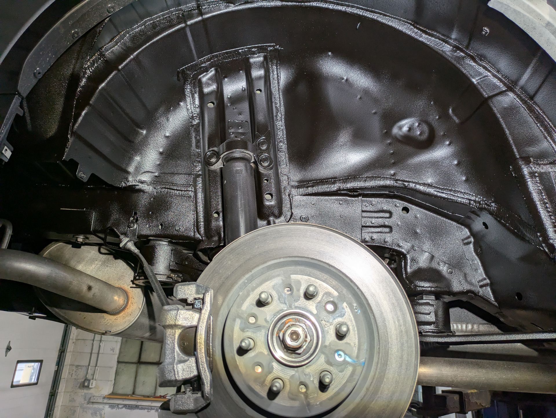 A close up of the underside of a car with a brake disc.