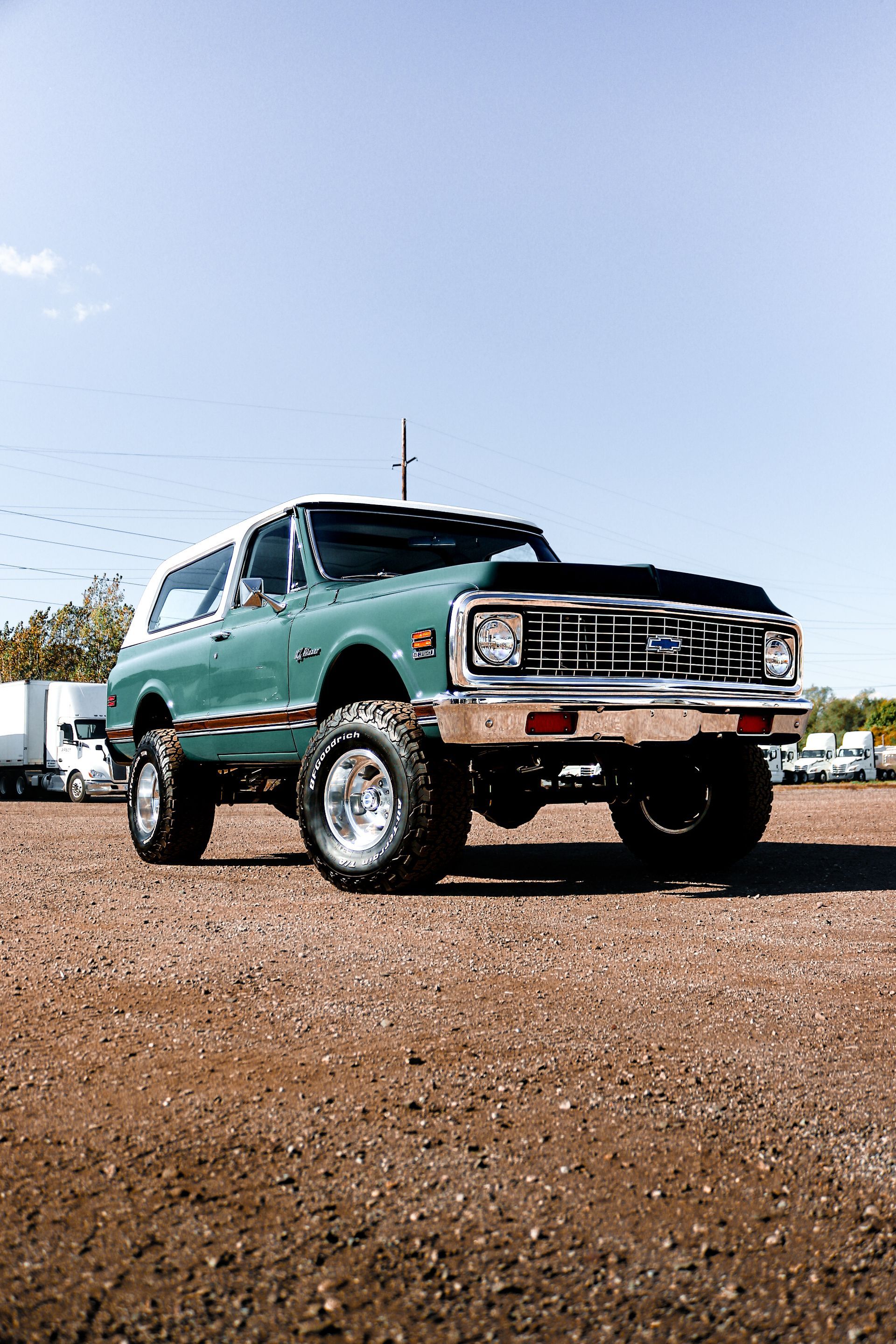 A green chevrolet blazer is parked in a gravel lot.