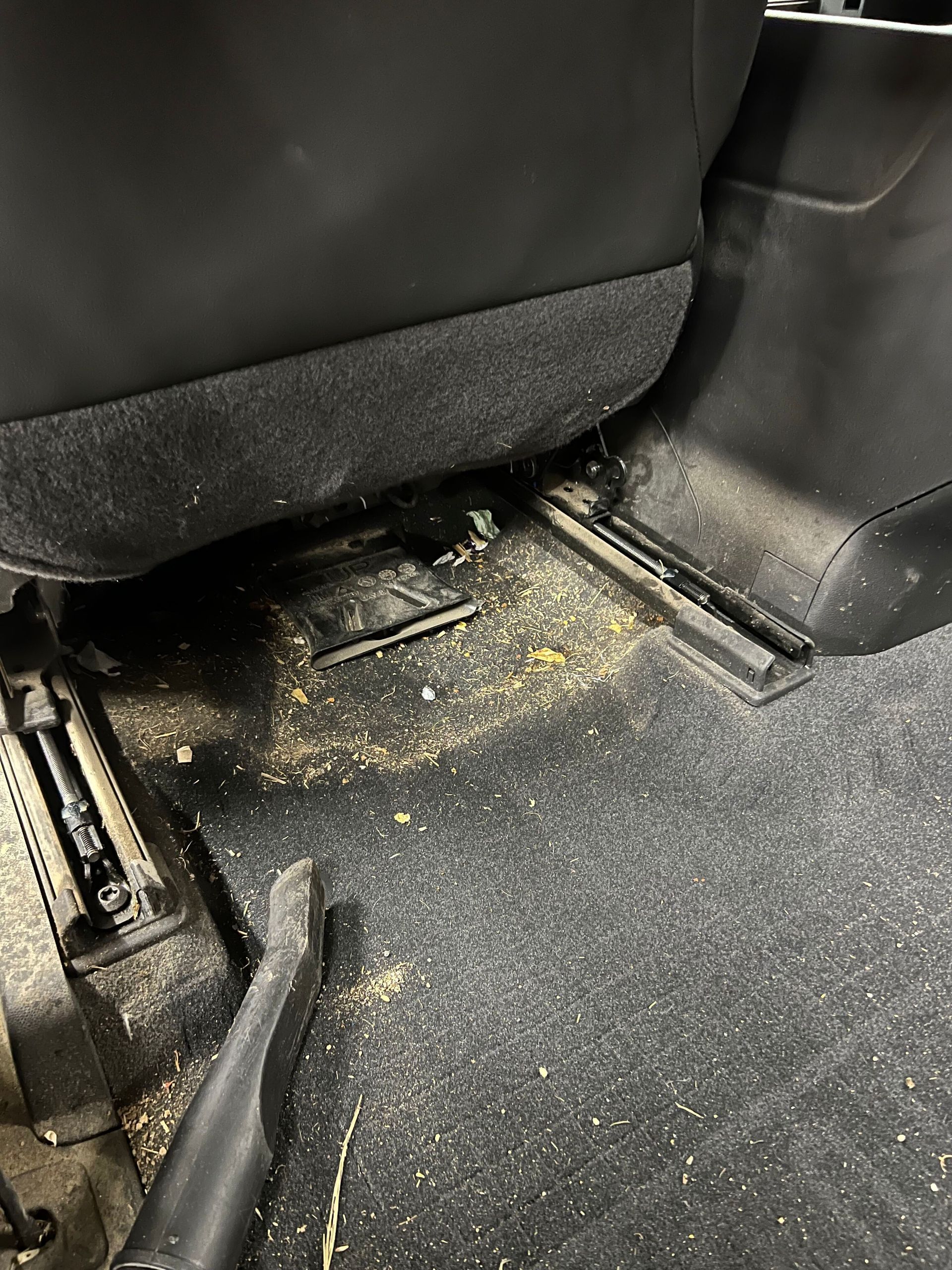 A vacuum cleaner is sitting on the floor of a car.