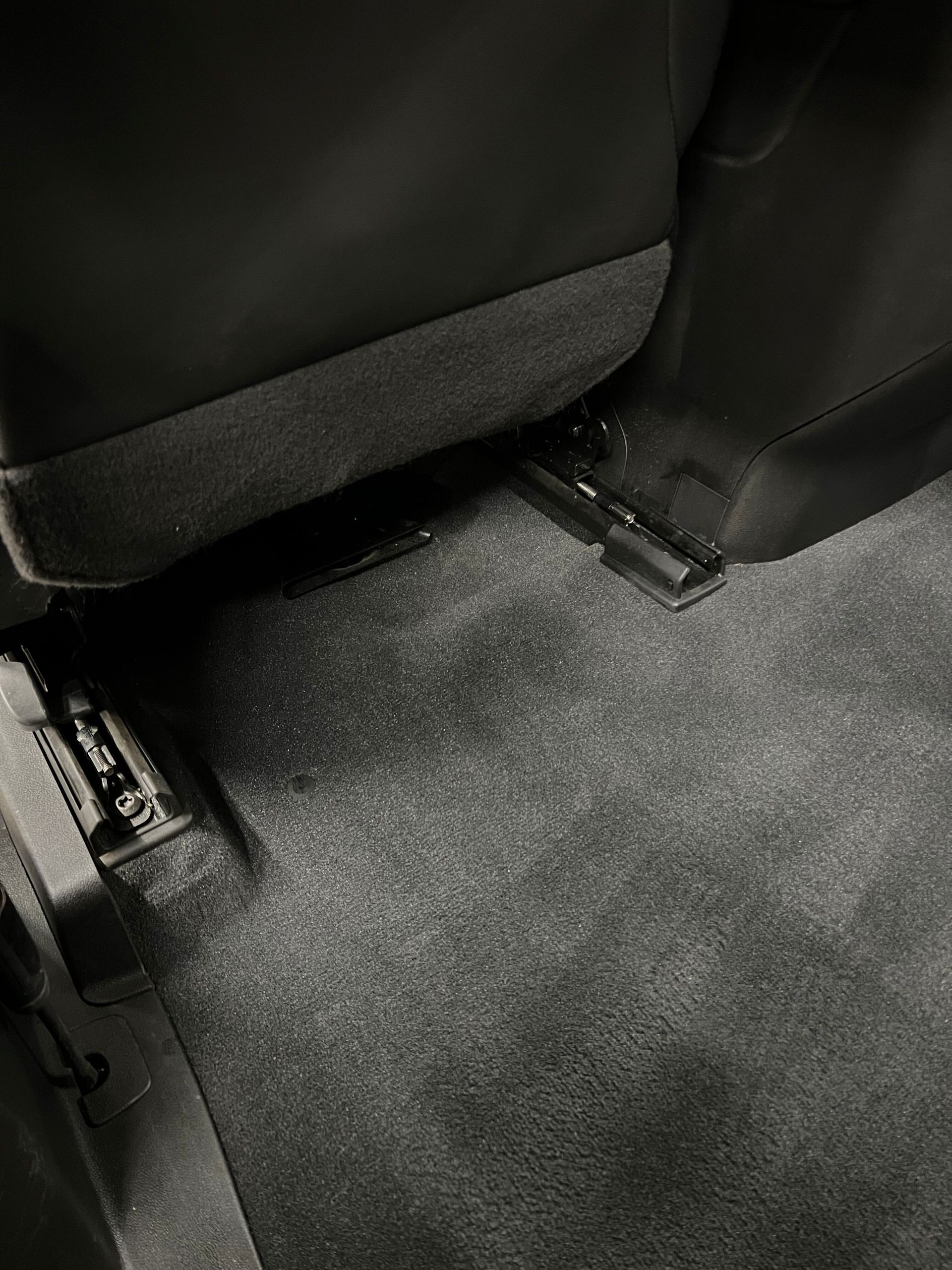 A black and white photo of the floor of a car.