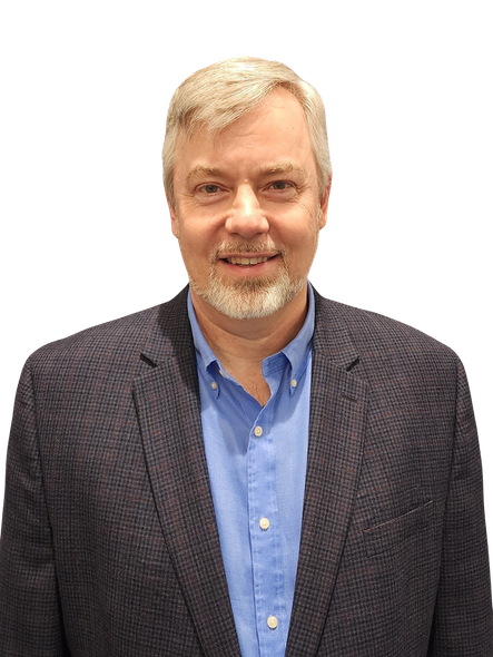 A man in a suit and blue shirt is smiling for the camera.