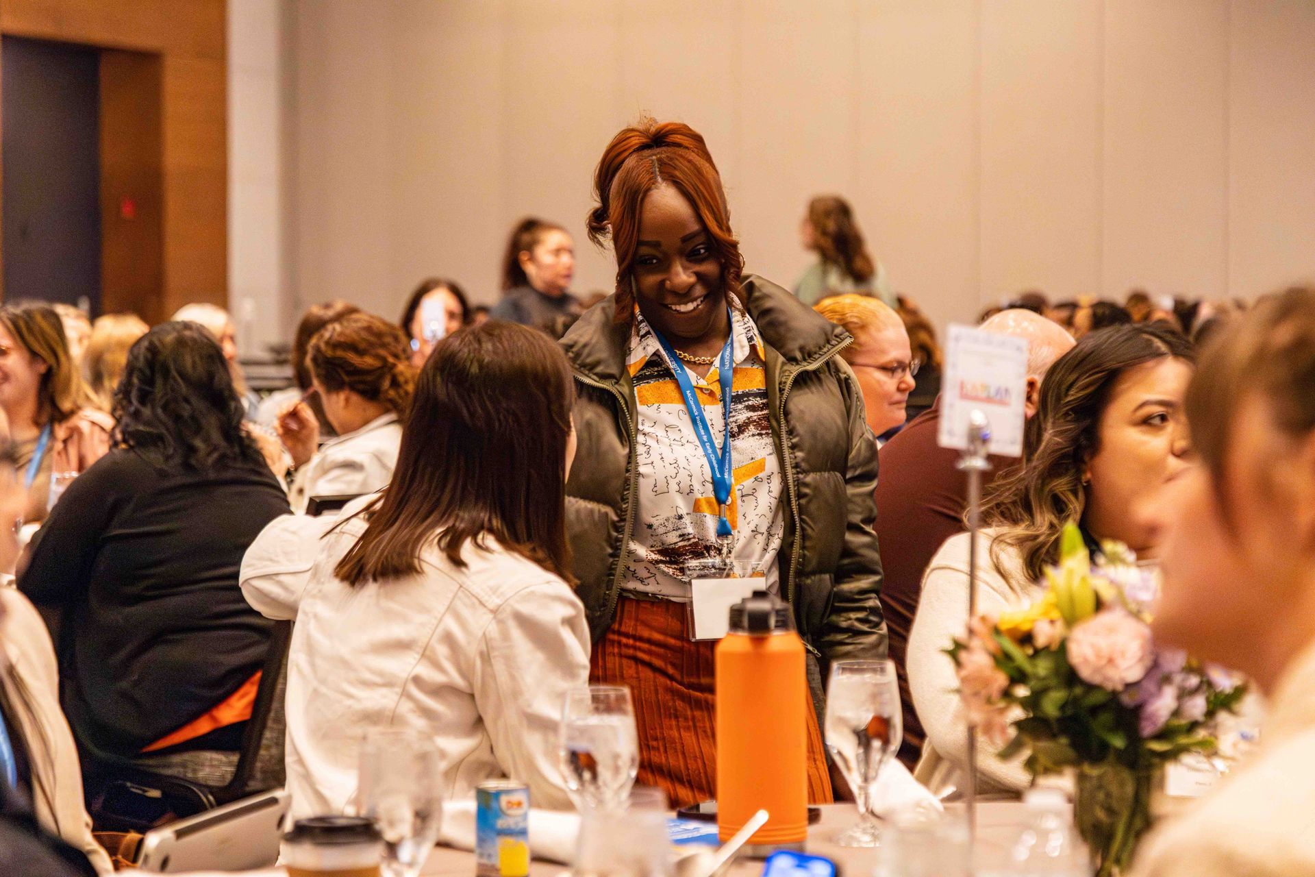 A group of people are sitting at tables at a conference.
