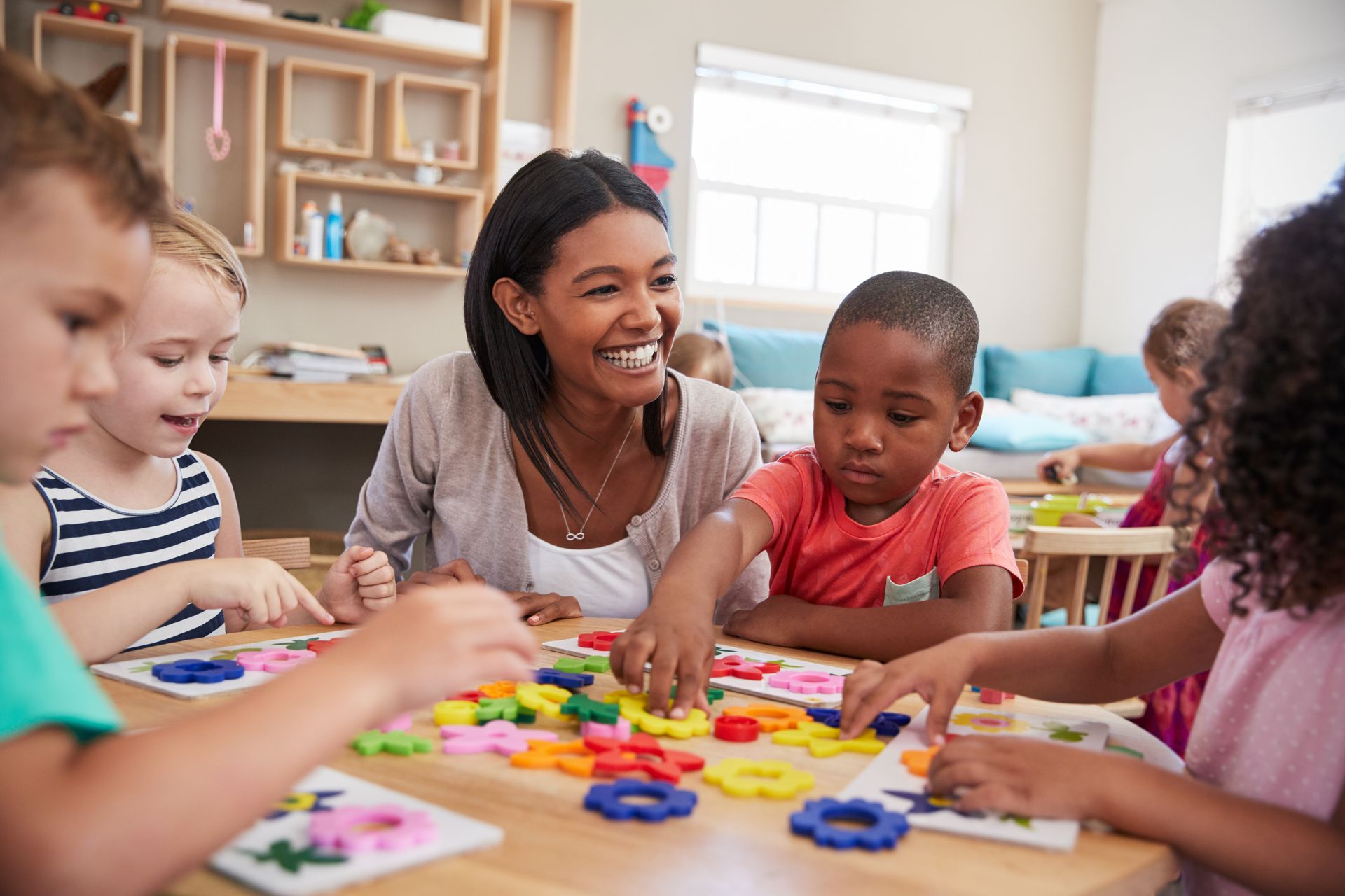 A teacher is teaching a group of children in a classroom.