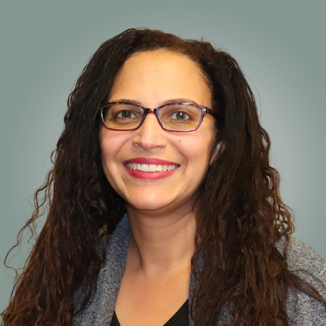 A woman in a black shirt is smiling for the camera