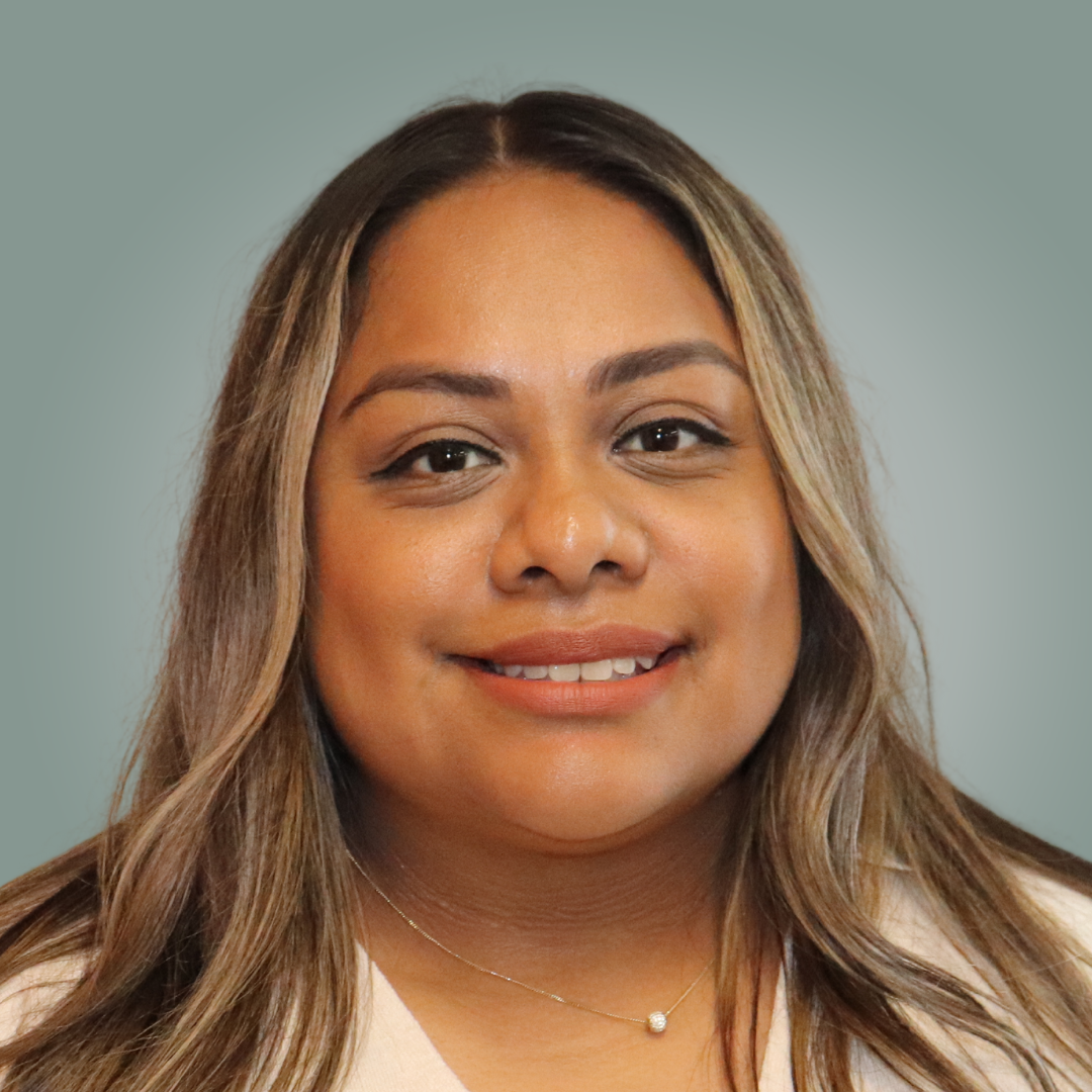 A woman with long brown hair is smiling for the camera