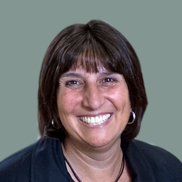 A woman with brown hair is smiling for the camera