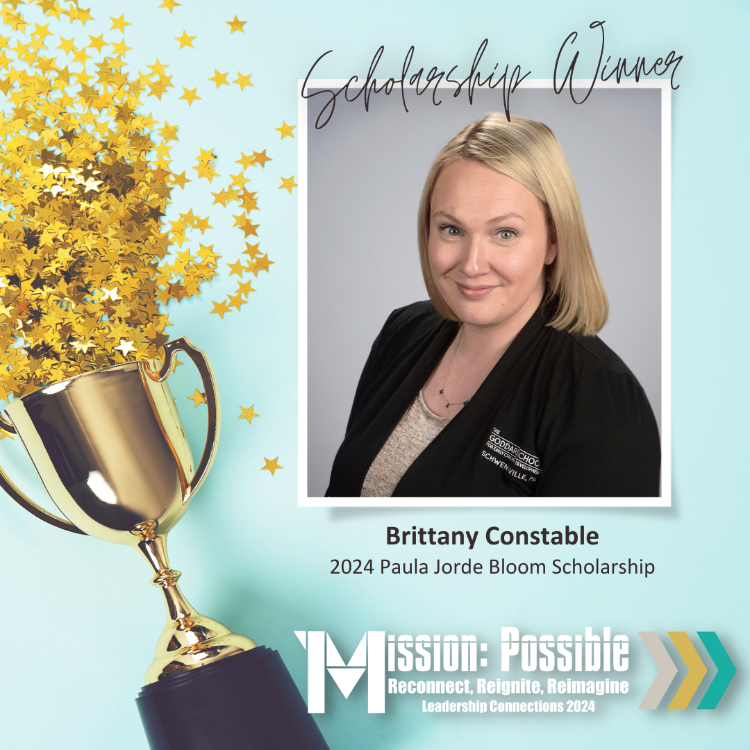 A woman is wearing a black jacket and smiling for the camera.