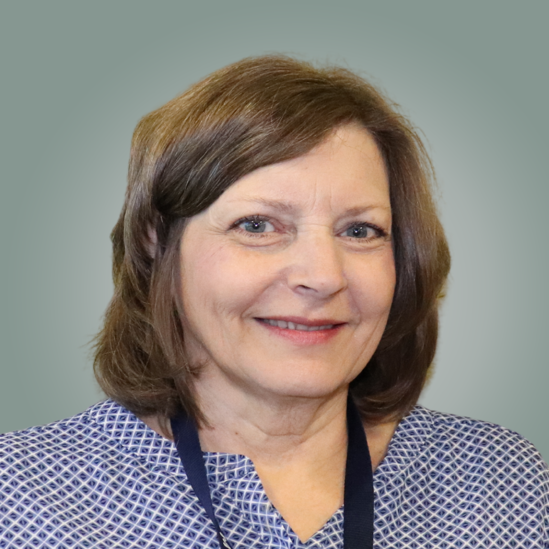 A woman with long brown hair is smiling for the camera