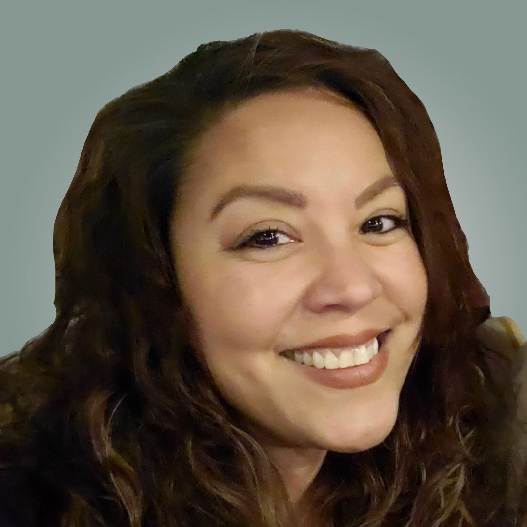 A woman with long brown hair is smiling for the camera.