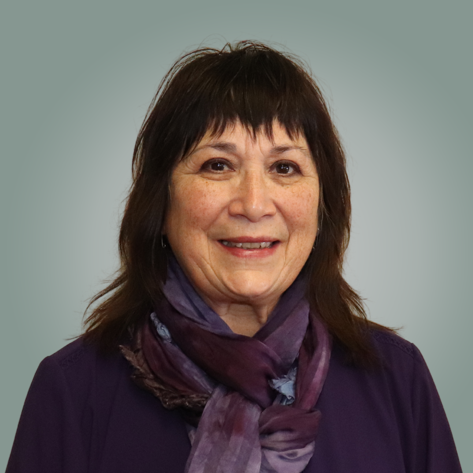 A woman wearing glasses and a black shirt is smiling for the camera.