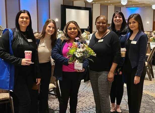 A group of women standing in front of a screen that says program administration scale
