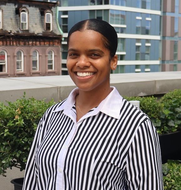 A woman wearing a black and white striped shirt is smiling