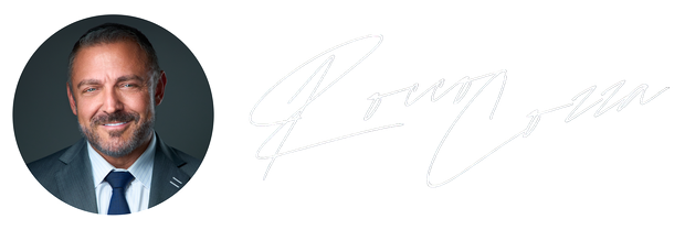 Headshot of a man in a suit with a signature to the right.