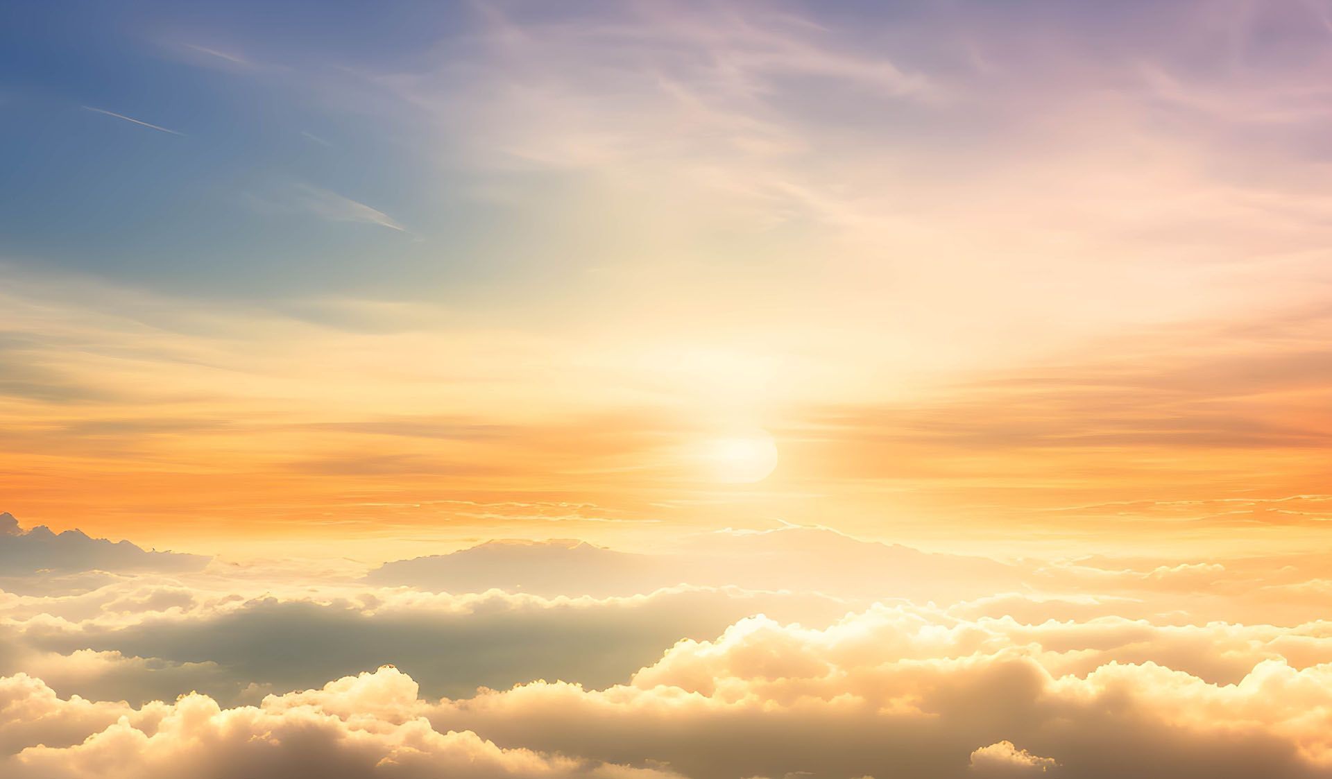 The sun is shining through the clouds at sunset.