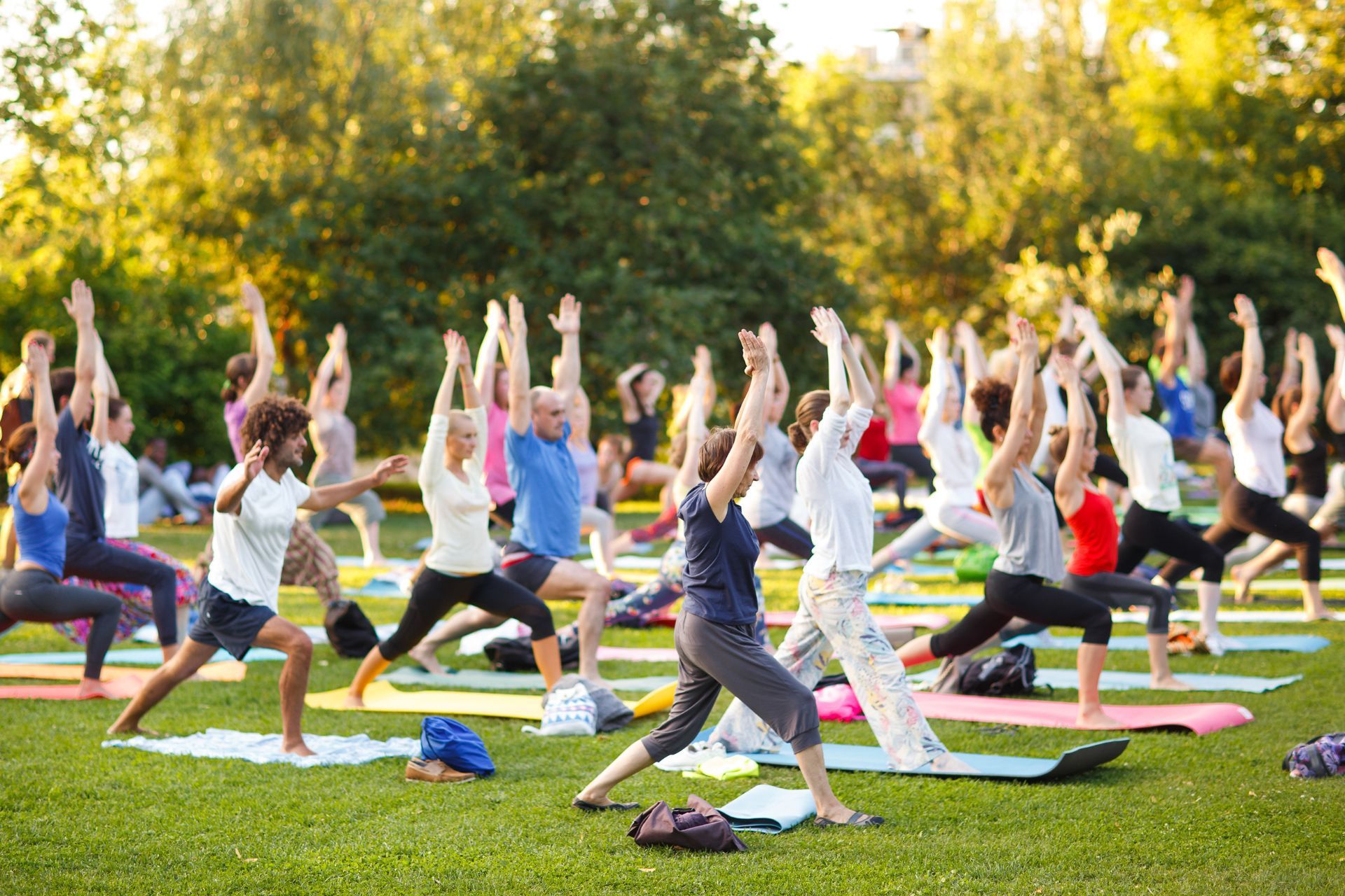a group of people are doing yoga in a park .