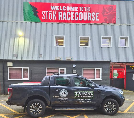 A van 1st choice Wrexham Locksmiths is parked in front of a building that says welcome to the stok racecourse Wrexham AFC