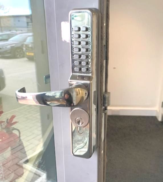 A close-up of Wrexham Locksimth fitting a door with a keypad on it.