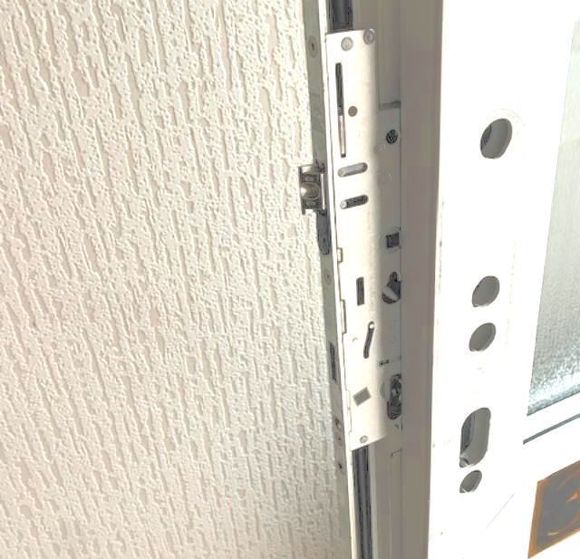 A close-up of a white uPVC door with a lock replacement