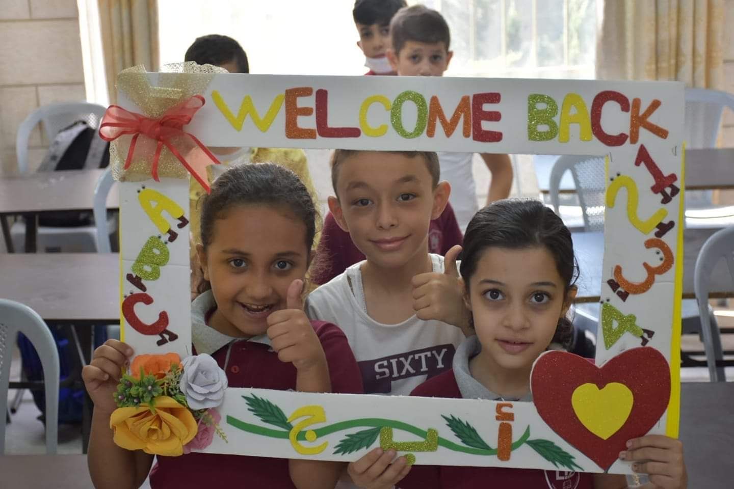 A group of children holding a welcome back sign