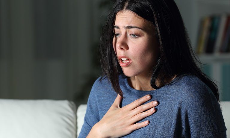 woman with hand over her heart - anxiety