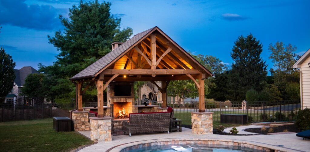 There is a gazebo in the backyard with a fireplace and a pool.