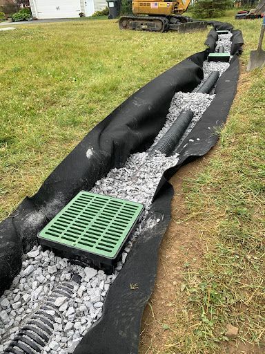 A drainage system is being installed in a yard.