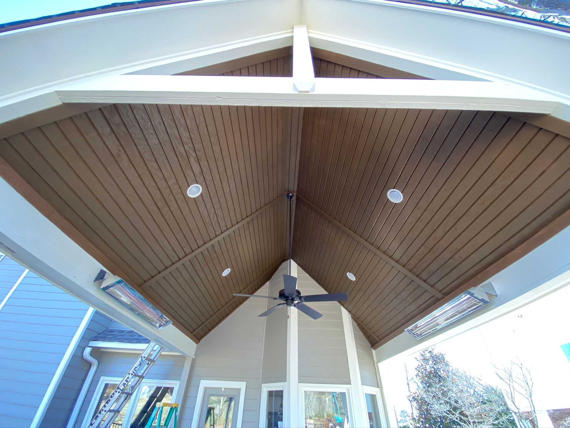 A backyard with a covered patio with a glass roof.