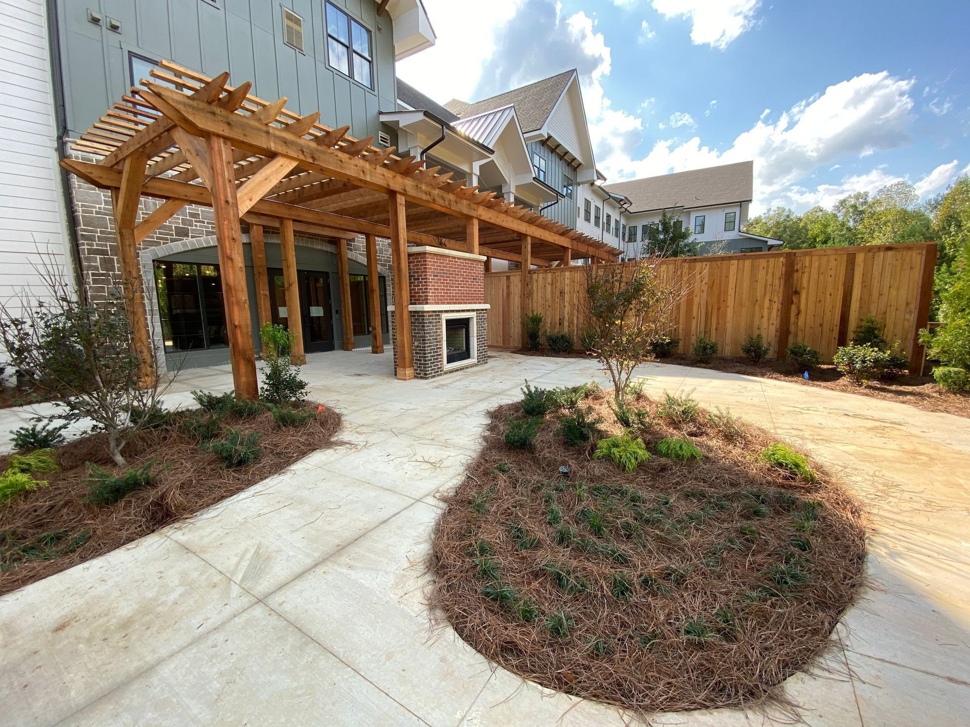 A patio with a wooden pergola and a wooden fence