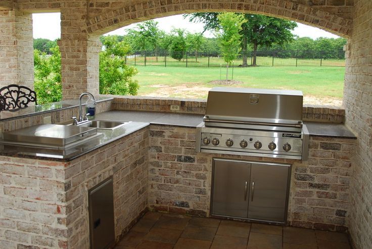 A patio with a grill and a ceiling fan