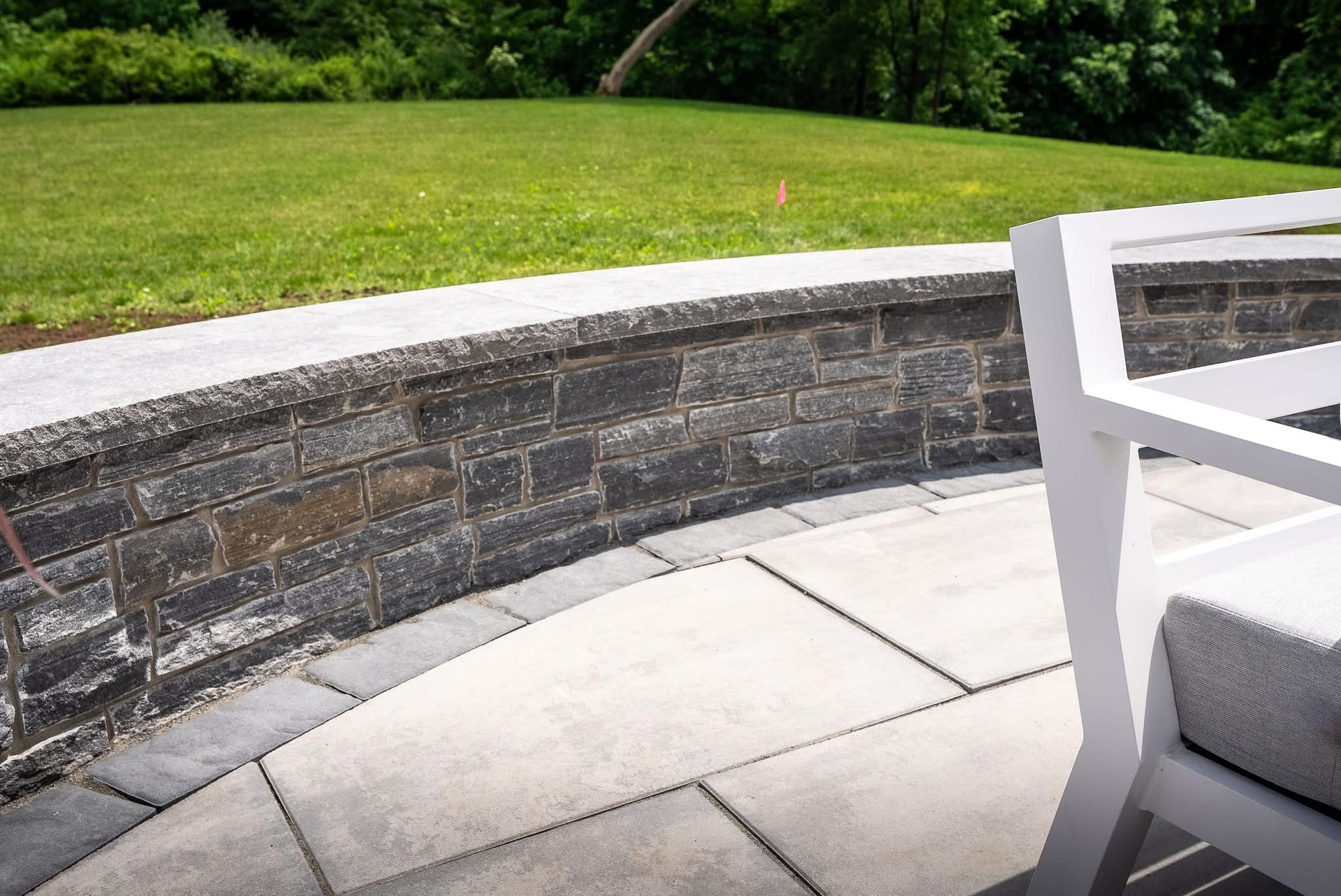 A patio with a fire pit and a couch and chair.