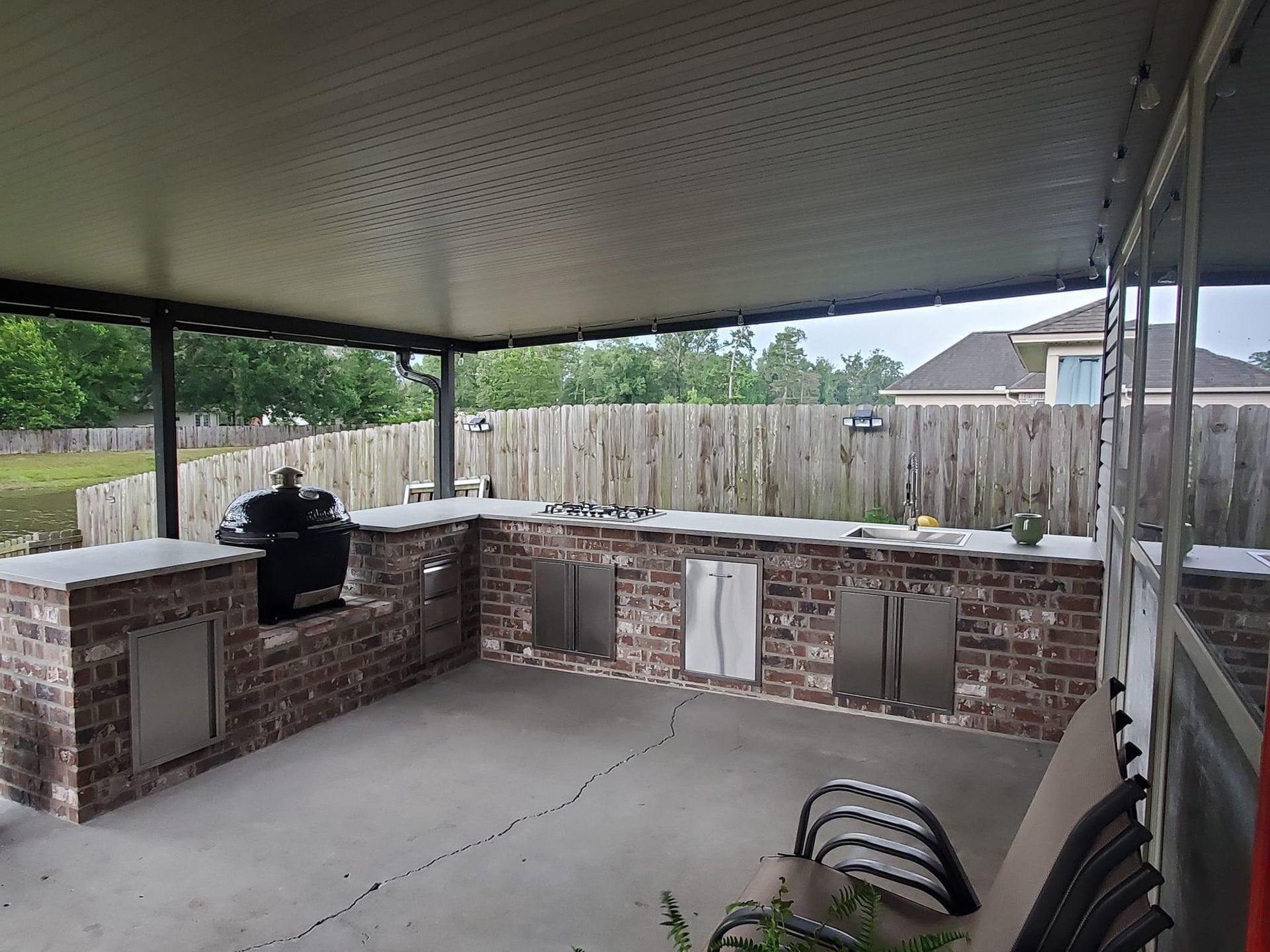 A large wooden pavilion with a kitchen in the backyard.