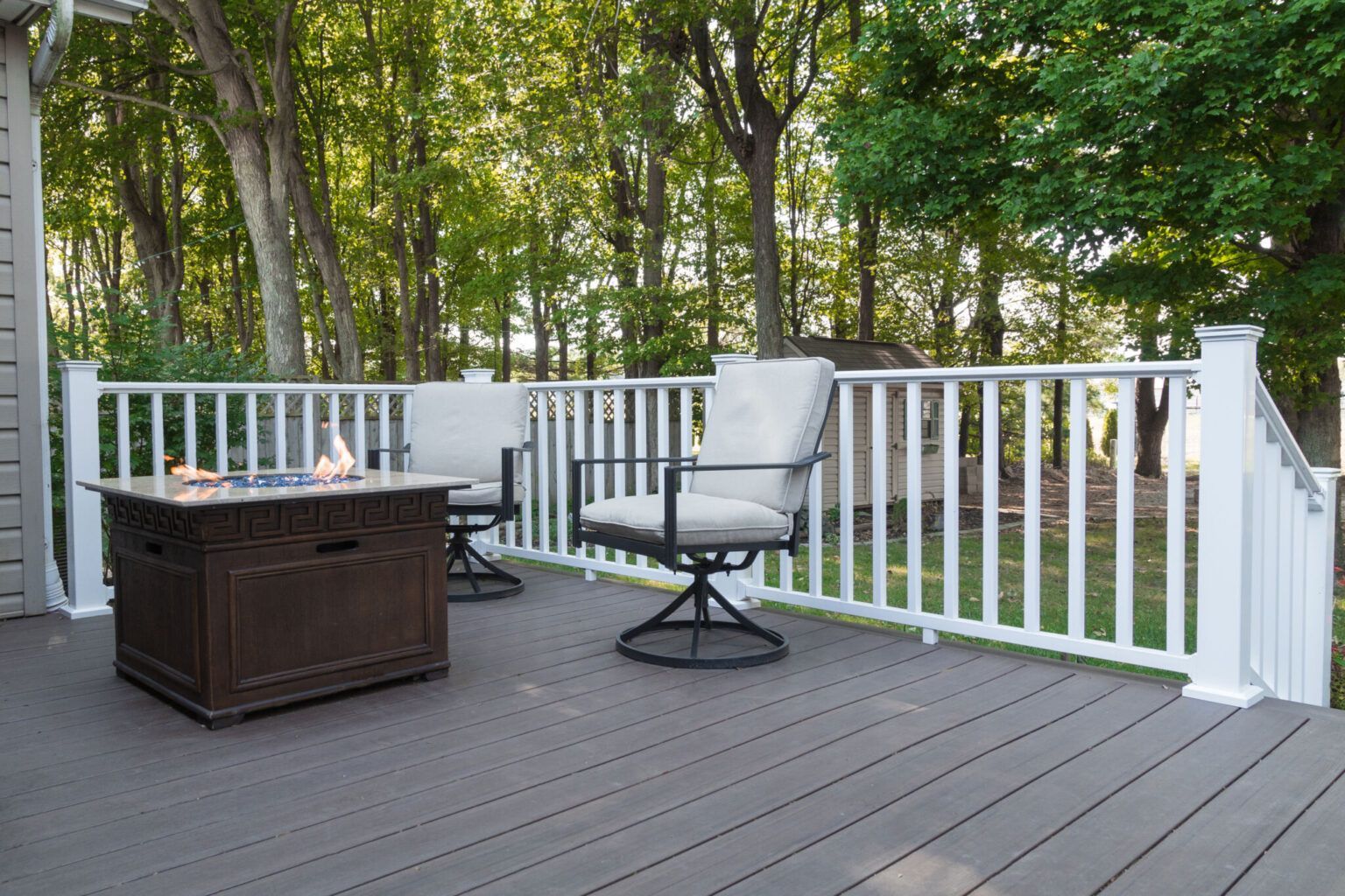 A wooden deck with a couch and a vase on it.