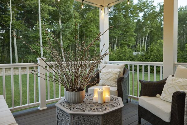 A screened in porch with chairs and a table with candles on it