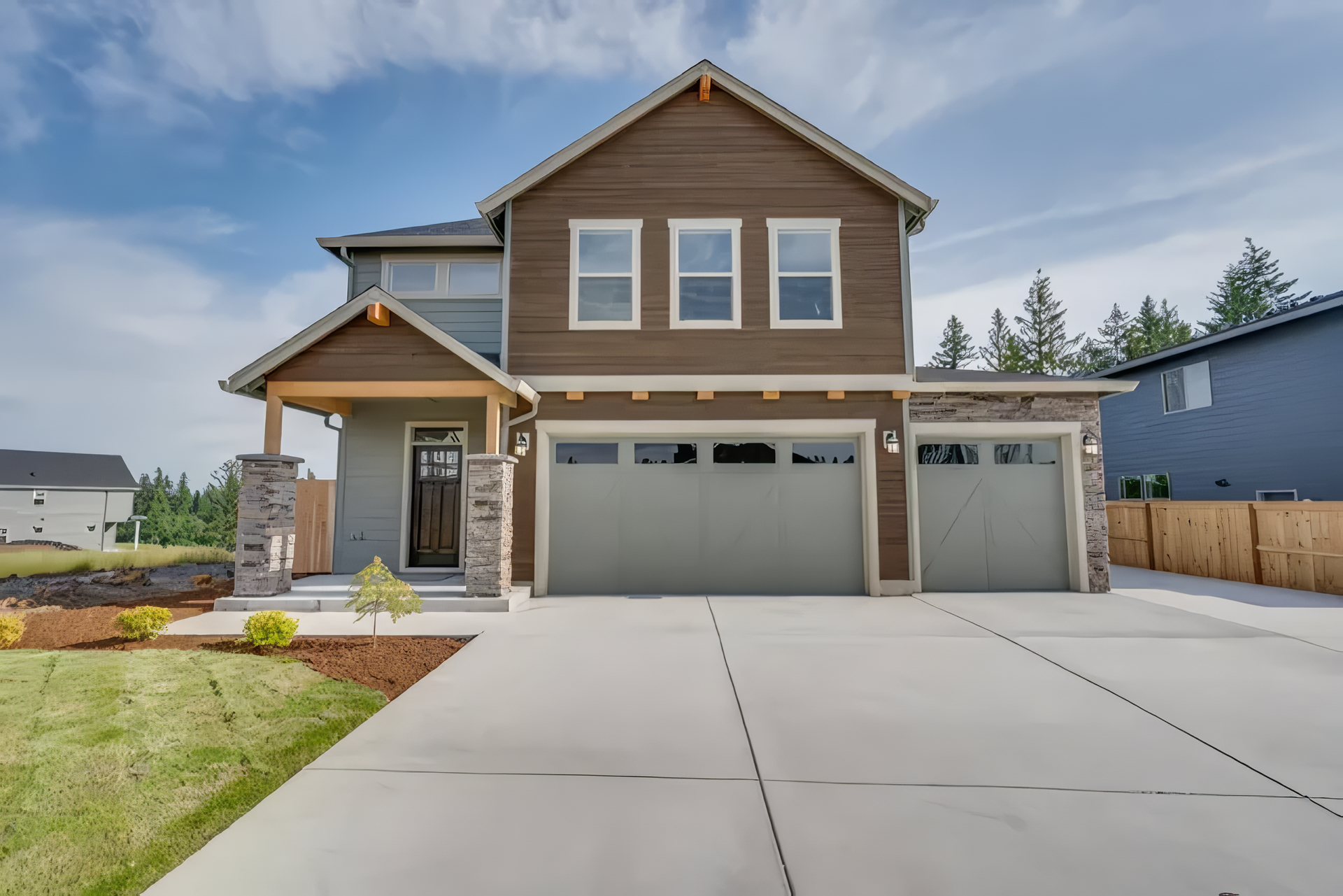 A house with three garage doors and a concrete driveway