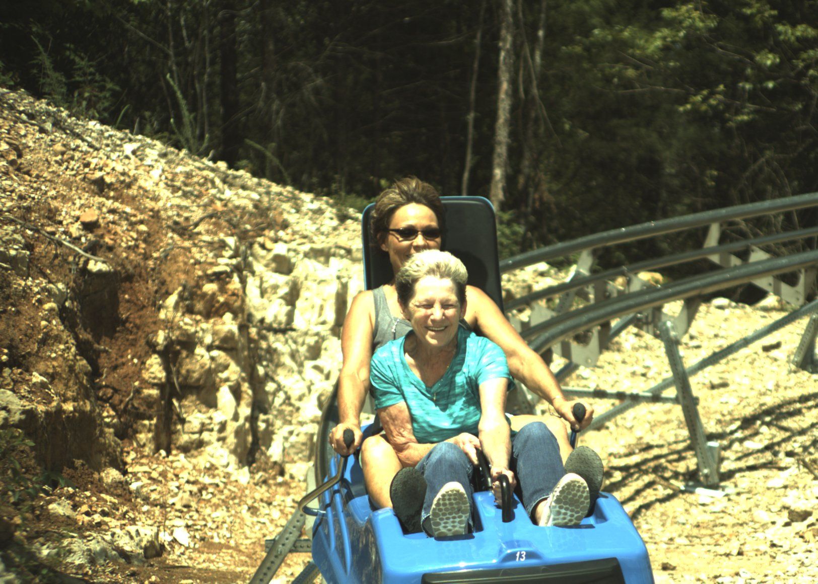 a mother and son on a mountain coaster ride